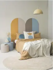  ?? ?? Add colour to your bedroom with a headboard painted in (from left) Resene Tide, Resene Tussock, Resene Nepal, Resene Americano and Resene Smooth Operator. Walls in Resene Triple Merino, floor in Resene Merino, bedside tables in Resene Tide and Resene Nepal. Duvet and bedlinen from Citta, blue cushion from Adairs. Project by Vanessa Nouwens, image by Melanie Jenkins.