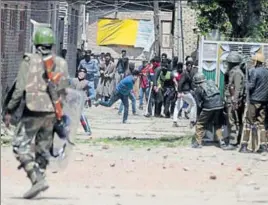  ?? WASEEM ANDRABI/HT ?? Kashmiri youths throw stones at soldiers outside a polling station near Srinagar.