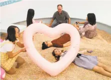  ?? Laura Morton / Special to The Chronicle ?? Visitors to the Museum of Ice Cream play in a pool of sprinkles — plastic ones, because the real thing would get a bit sticky.