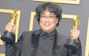  ?? STRAUSS/INVISION JORDAN ?? Director Bong Joon Ho holds two of the four awards for his film“Parasite”at the Oscars on Feb. 9.