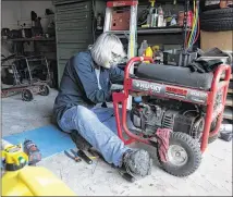  ?? HYOSUB SHIN / AJC ?? Nichole Koonce fixes one of three generators she has been using since her house lost power after Tropical Storm Irma hit her Snellville neighborho­od. About 548,000 Georgia homes and businesses remained without power at mid-day Wednesday.