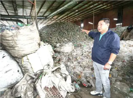  ?? — Chris Navarro ?? MOUNTAINS OF PLASTIC. Sto.Tomas Mayor John Sambo points to piles of plastic at the MMK recycling plant in Barangay San Matias which was closed by the local government, BFP and PNP yesterday for alleged violations and operating without a business permit.