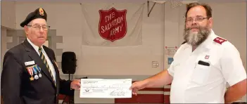  ??  ?? Neville Royal Canadian Legion President Keith Carleton makes a $300 donation in support of the Swift Current Salvation Army Food Bank to Major Ed Dean.