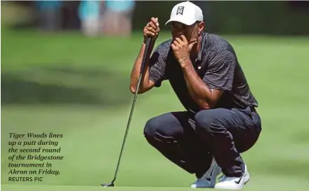  ?? REUTERS PIC ?? Tiger Woods lines up a putt during the second round of the Bridgeston­e tournament in Akron on Friday.