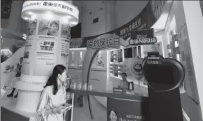  ?? PROVIDED TO CHINA DAILY ?? A visitor walks past Nestle’s booth at an exhibition of dairy products held in Beijing.