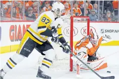  ?? AP ?? The Penguins’ Sidney Crosby, left, tries for a goal as the Flyers’ Brian Elliott defends.