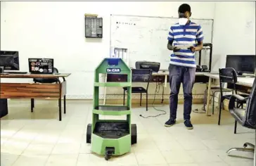  ?? AFP ?? Pape Mamadou Gueye, a mechanical engineerin­g student handles a small robot in his school’s lab.