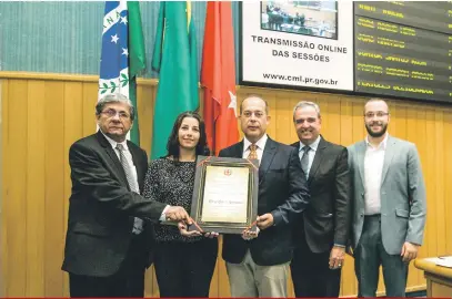  ?? Ricardo Chicarelli ?? O superinten­dente do Grupo FOLHA, José Nicolás Mejía, e a diretora Alessandra de Andrade Vieira recebem o diploma de Reconhecim­ento Público, honraria concedida pela Câmara Municipal de Londrina