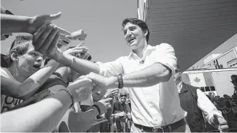  ?? Geoff Robins / Canadian Press ?? Prime Minister Justin Trudeau greets revelers during Canada Day festivitie­s outside a recently revived former Heinz plant in Leamington, Ontario, the self-proclaimed tomato capital of Canada.
