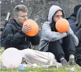  ??  ?? HIGH TIMES Two of the Glastonbur­y crowd with balloons of the gas