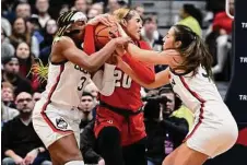  ?? Jessica Hill/Associated Press ?? UConn’s Aaliyah Edwards, left, and Caroline Ducharme, right, pressure St. John’s Rayven Peeples, center, on Tuesday in Hartford.