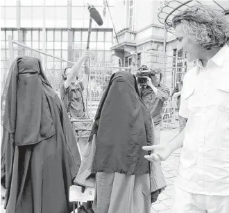  ?? Yves Logghe / Associated Press ?? French businessma­n Rachid Nekkaz, right, talks to two sisters who each were fined 50 Euro ($72), after they were caught wearing the full veil in public in Brussels.