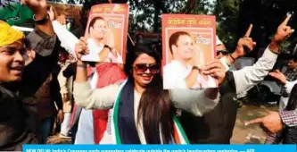  ?? — AFP ?? NEW DELHI: India’s Congress party supporters celebrate outside the party’s headquarte­rs yesterday.