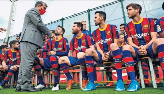  ??  ?? Lapota habla con Piqué, en presencia de Messi, Busquets y Sergio Roberto, en el acto de la foto oficial de la plantilla.