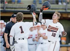  ?? BY BRYAN TERRY, THE OKLAHOMAN] [PHOTOS ?? Oklahoma State’s Cade Cabbiness (16) celebrates with Ryan Cash after hitting a two-run home run in the second inning of a Bedlam game between in Stillwater on April 27.