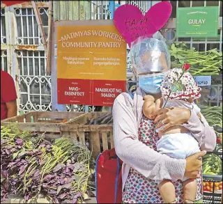  ?? EDD GUMBAN, WALTER BOLLOZOS ?? CELEBRATIN­G MOTHERHOOD: A woman clutches her five-month-old baby as she takes food items from the community pantry set up by labor group Defend Jobs Philippine­s along Matimyas street in Sampaloc, Manila to celebrate Mother’s Day yesterday. At right, personnel of the Philippine Air Force’s 220th Airlift Wing pose for a group photo while flying in a C130 plane yesterday. Lower photo shows shoppers making last-minute purchases at the Dangwa flower market in Manila on Saturday.