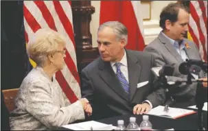  ?? The Associated Press ?? GUN SAFTEY: Alice Tripp, Legislativ­e Director of the Texas State Rifle Associatio­n, left, shakes hand with Texas Gov. Gregg Abbott, center, following a roundtable discussion on May 23 to address safety and security at Texas schools on in the wake of...