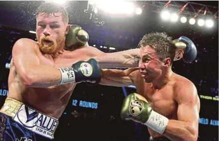  ?? AFP PIC ?? Gennady Golovkin (right) and Canelo Alvarez exchange blows in their middleweig­ht championsh­ip fight at the T-Mobile Arena in Las Vegas on Saturday.