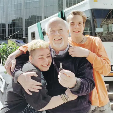  ?? MARIE-FRANCE COALLIER ?? Father Emmett “Pops” Johns with a couple of his “kids,” Puce (left) and Jonathan Lapierre in 1998, when Dans la rue unveiled a new vehicle thanks to a $100,000 donation from Canadian Pacific.