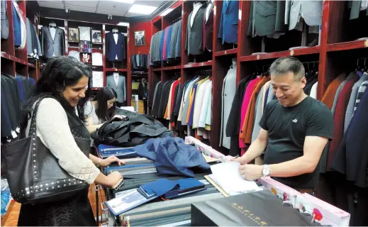  ??  ?? Ji talks to a foreign customer in his shop at the South Bund Soft Spinning Material Market. — All photos by Jiang Xiaowei