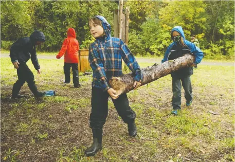  ?? JEAN LEVAC ?? Teddy, left, and Brennan, right, Grade 4 students at Rivière Rideau school in Kemptville, help build an outdoor structure during a “forest school” period earlier this month. Students at the school spend time on outdoor activities that teachers link to in-class lessons.