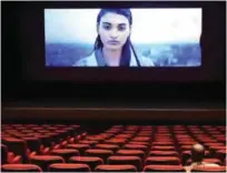  ??  ?? A man watches the announceme­nts before the start of a movie.