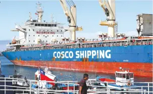  ?? (Rodrigo Garrido/Reuters) ?? A MAN walks near a China Ocean Shipping Company container ship at the Valparaiso Port, Chile, last year. The company’s entry into the Israeli market will increase competitio­n, reduce transporta­tion times and lower prices.