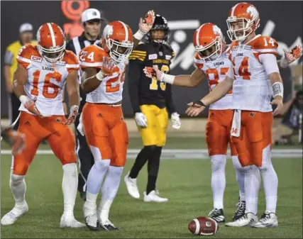  ?? JOHN RENNISON, THE HAMILTON SPECTATOR ?? Ticats’ Justin Rogers, centre, watches as the Lions’ Jeremiah Johnson, second left, celebrates his touchdown reception on a pass from Travis Lulay, right.