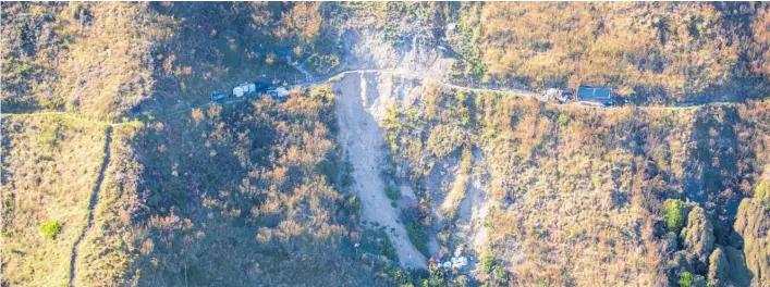  ?? Photo / Mark Mitchell ?? Abseilers at work stabilisin­g a large slip on the Paeka¯ ka¯ ki Escarpment Track.