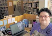  ?? TONY DEJAK / AP ?? Nikki Luman, who works part-time for a local library, poses at her desk, Monday in Sycamore, Ohio.