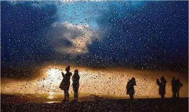  ?? Santiago Mejia/The Chronicle ?? Raindrops are seen through a car window as people visit Twin Peaks in San Francisco on Thursday, when a blast of winter weather caused persistent delays on BART and made several roads impassable.