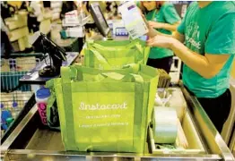  ?? PATRICK T. FALLON BLOOMBERG ?? Propositio­n 22 allows Instacart and other “network companies” to classify app-based drivers as independen­t contractor­s if they meet certain criteria.