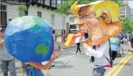  ?? REUTERS ?? Protesters dressed as the earth and Donald Trump have a mock fight in Washington.