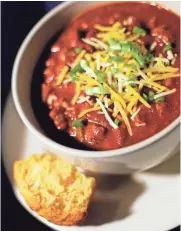  ?? AMY LEANG/DETROIT FREE PRESS ?? Chili garnished with cheese and green onions and served with a side of cornbread is perfect for a cold winter night.