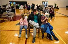  ?? Emily Elconin / New York Times ?? A father with his children after they got their COVID vaccines in 2021. The FDA appears set to OK vaccines for young children.