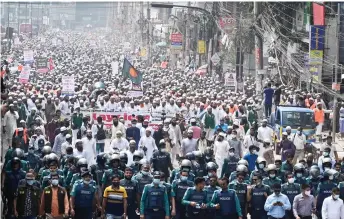  ?? — AFP photo ?? Activists and supporters of the Islami Andolon Bangladesh party hold a protest march calling for the boycott of French products and denouncing Macron for his comments over Prophet Mohammed caricature­s, in Dhaka.