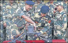  ?? AFP ?? BSF commandant Jasbir Singh (C) and other officers showing the drone downed near the border outpost of Daoke in Amritsar on Saturday.