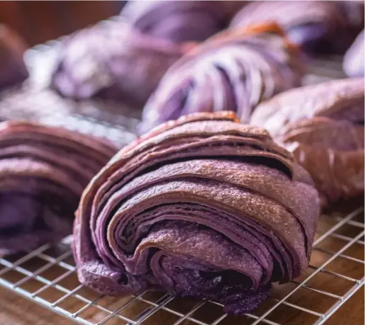  ?? MANUEL MARTINEZ/WBEZ ?? LEFT: Michelle Anselmo’s croissants — made with ube, a purple yam common in the Philippine­s and incorporat­ed into the dough itself — are striking in color and shape, with their modern, slashed tops.