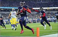  ?? ASHLEY LANDIS / AP ?? Titans free safety Kevin Byard scores a touchdown after grabbing an intercepti­on during the first half of Sunday’s game against the Rams in Inglewood.