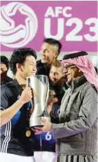  ??  ?? DOHA: AFC president Sheikh Salman bin Ebrahim Al Khalifa (R) presents Japan’s captain Wataru Endo (L) with the trophy following the AFC U23 Championsh­ip final football match between Japan and South Korea at Abdullah Bin Khalifa Stadium in Doha...