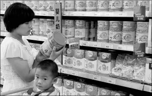  ?? SI WEI / FOR CHINA DAILY ?? A woman chooses formula milk powder at a supermarke­t in Ganyu, Jiangsu province.