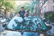  ?? (Courtesy Photo/Lisa Tolin) ?? Journalist Mark Kennedy poses with his kids popping out of the sunroof of his first car, a 2015 Mazda CX-5, in the Brooklyn borough of New York. The pandemic has altered so much in America in ways great and small. The subways, buses and ride-sharing platforms are trips not for the nervous and car-sharing services aren’t practical or economical for long-term rentals.