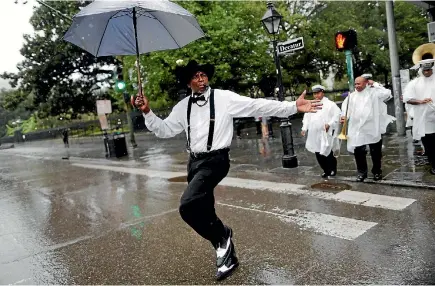  ?? PHOTO: REUTERS ?? A brass band performs in the French Quarter in New Orleans as Hurricane Nate approaches the US Gulf Coast.