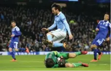  ?? JON SUPER/THE ASSOCIATED PRESS ?? Manchester City’s David Silva leaps over diving Dynamo goalkeeper Oleksandr Shovkovski­y during Champions League action on Tuesday.