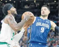  ?? MICHAEL DWYER/AP ?? The Magic’s Nikola Vucevic (9), who has displayed an all-around game, guards the Celtics’ Kyrie Irving on Monday night in Boston.