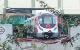  ?? HT ?? The Metro trial run on the new Magenta line ended in an accident on Tuesday when a train, as seen in this picture clicked by a bystander, broke through a wall at the Kalindi Kunj depot. The train was being moved up a ramp for washing when it rolled...