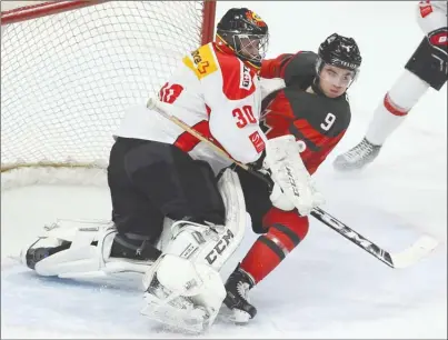  ?? The Canadian Press ?? Team Canada forward Dillon Dube (9), of the WHL’s Kelowna Rockets, crashes into Switzerlan­d goalie Philip Wuthrich during Friday’s exhibition game in Hamilton, Ont., ahead of the 2018 World Junior Hockey Championsh­ip, which begins Boxing Day in...