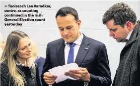  ??  ?? > Taoiseach Leo Varadkar, centre, as counting continued in the Irish General Election count yesterday