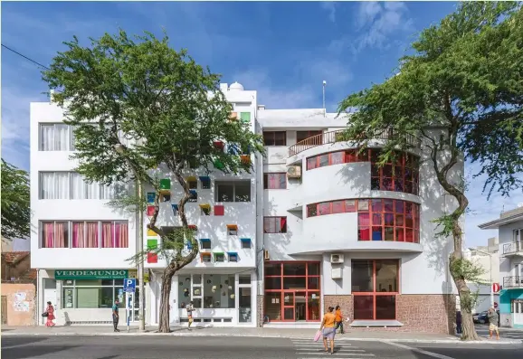  ??  ?? ABOVE: The chromatic apertures of Casa Celestina, a four-storey mixed-used complex in a pedestrian streetscap­e in Mindelo, are inspired by the tones of nearby singlestor­ey homes.