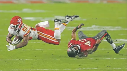  ?? MARK LOMOGLIO/ASSOCIATED PRESS FILE PHOTO ?? Chiefs running back Clyde Edwards-Helaire gets tripped up by Buccaneers defensive back Ross Cockrell on Nov. 29 in Tampa, Fla. Kansas City can lock up a playoff berth Sunday by beating or tying with the Dolphins.